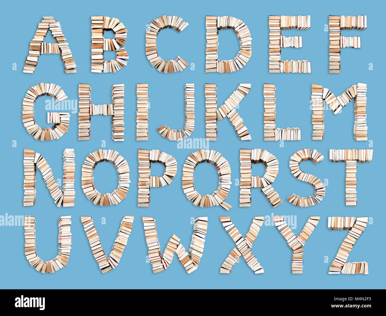 Set of capital Alphabet letters formed from books, shot from above on light blue background Stock Photo