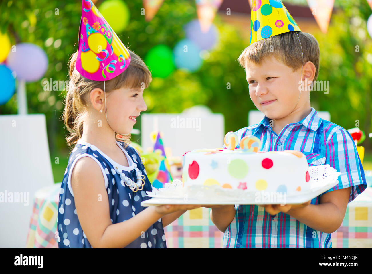 Little girl giving a birthday cake to her friend Stock Photo Alamy