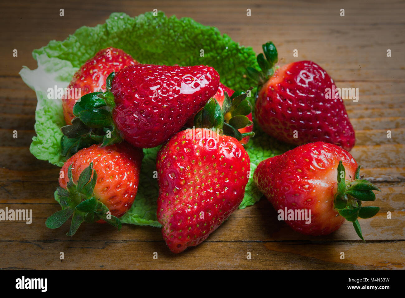 Still life of a composition of ripe and juicy strawberries over a wooden board. Abruzzo, Italy, Europe Stock Photo