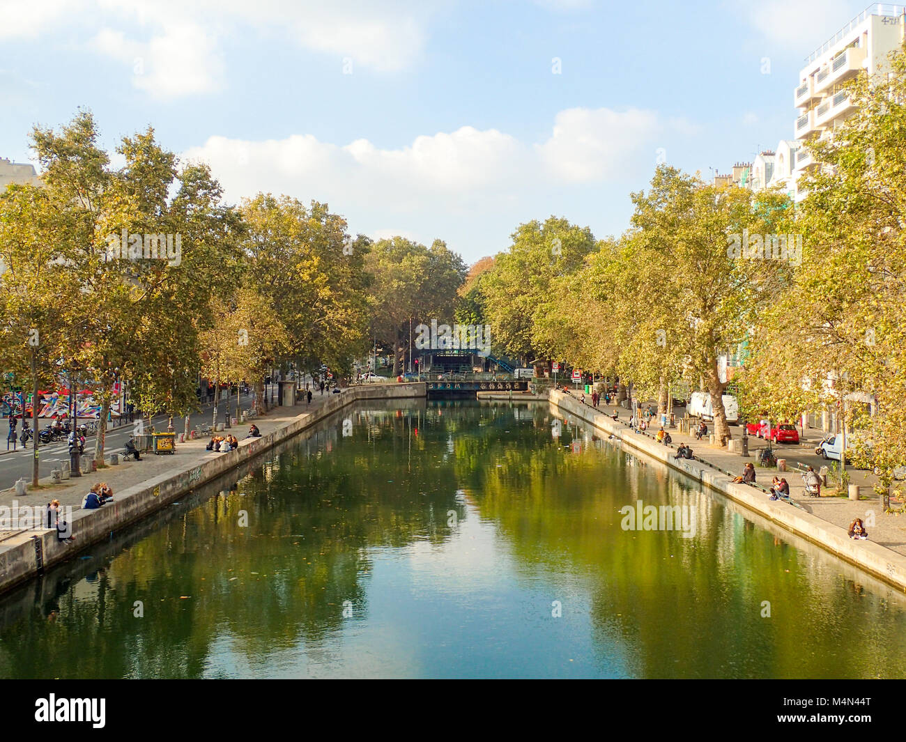 People relax on the edge of the Canal Saint-Martin in Paris Stock Photo