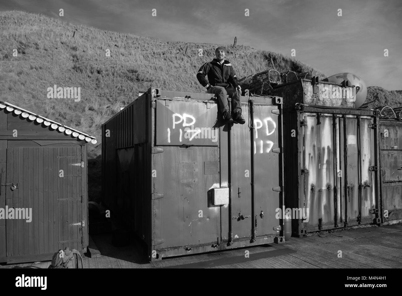 Sitting on shipping container Black and White Stock Photos & Images - Alamy