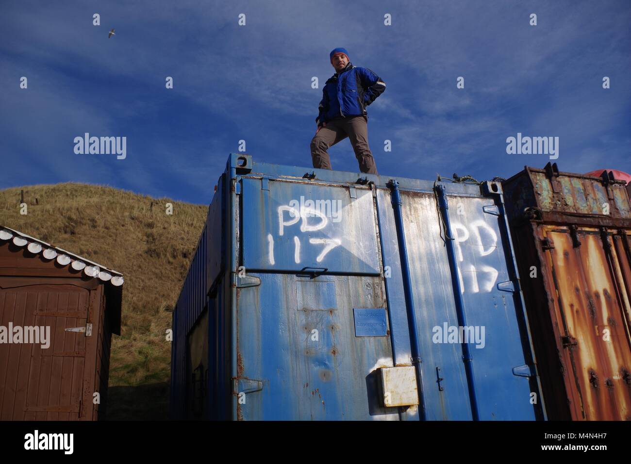 Young British Man On Top of a Used Storage Shipping Container. Port ...