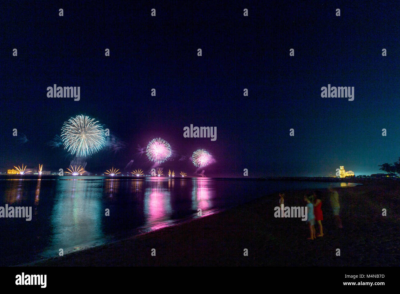 Ras Al Khaimah, United Arab Emirates. 15th Feb, 2018. People seen enjoying the firework from the beach. The UAE Ministry of State for Happiness launched its first Happiness Festival of 2018 in Ras Al Khaimah. The UAE is the only country in the world that has a Ministry for happiness and positivity. A key feature of the Festival is that it ends with a fireworks display. The Waldorf Astoria Ras Al Khaimah is seen in the distance during the fireworks display. Credit: Mike Hook/SOPA/ZUMA Wire/Alamy Live News Stock Photo