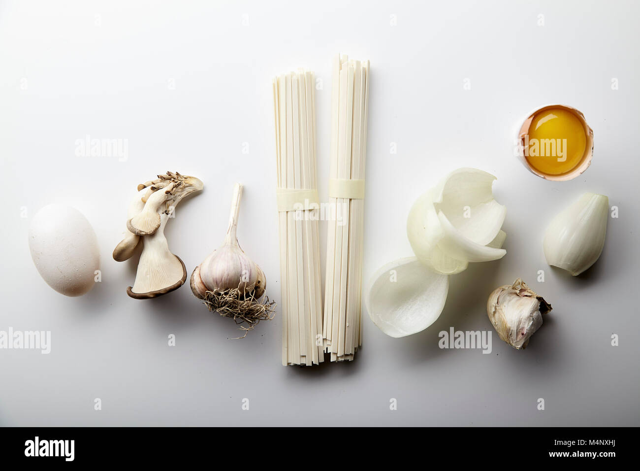 Asian cuisine ingredients on white background. Udon noodles, egg yolk