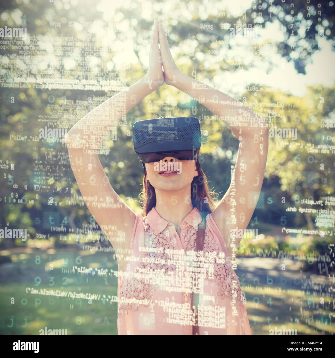 Woman standing with her hands joint while using a VR 3d headset in the park Stock Photo
