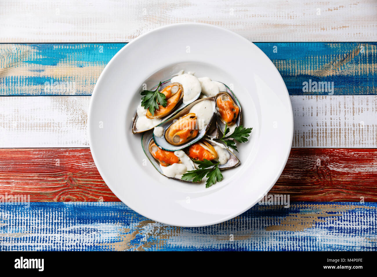 Shellfish Mussels Clams on plate with blue cheese sauce and parsley Stock Photo