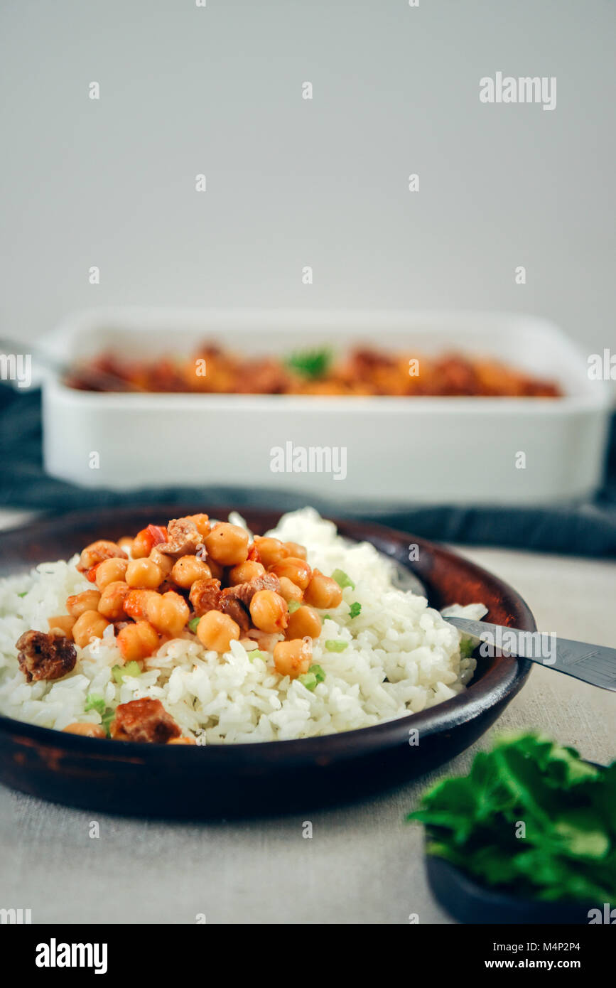 Simple fried rice topped with garbanzo beans and beef stew in a dark