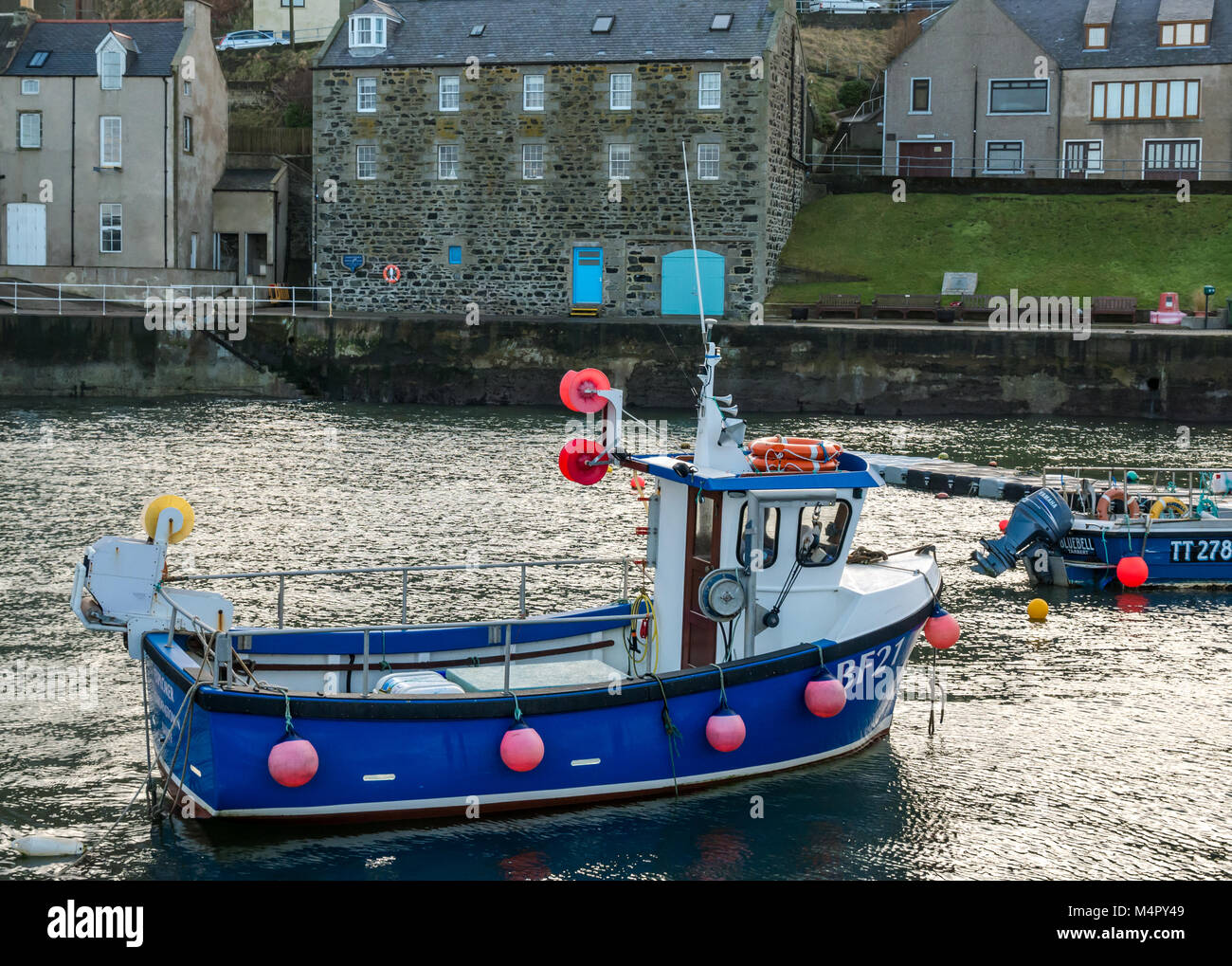 Small fishing boats in harbour, picturesque seaside village of Gardenstown, Aberdeenshire, Scotland, UK Stock Photo