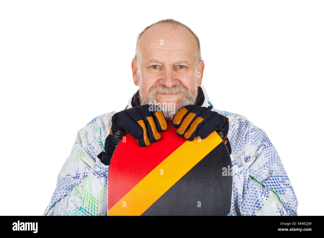Handsome senior man holding his snowboard and smiling to the camrea on ...