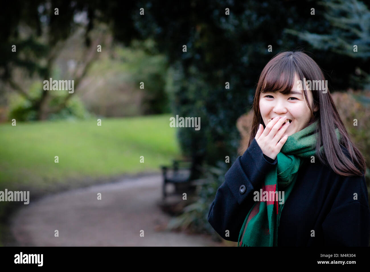 A beautiful young Japanese lady in the park laughing Stock Photo - Alamy