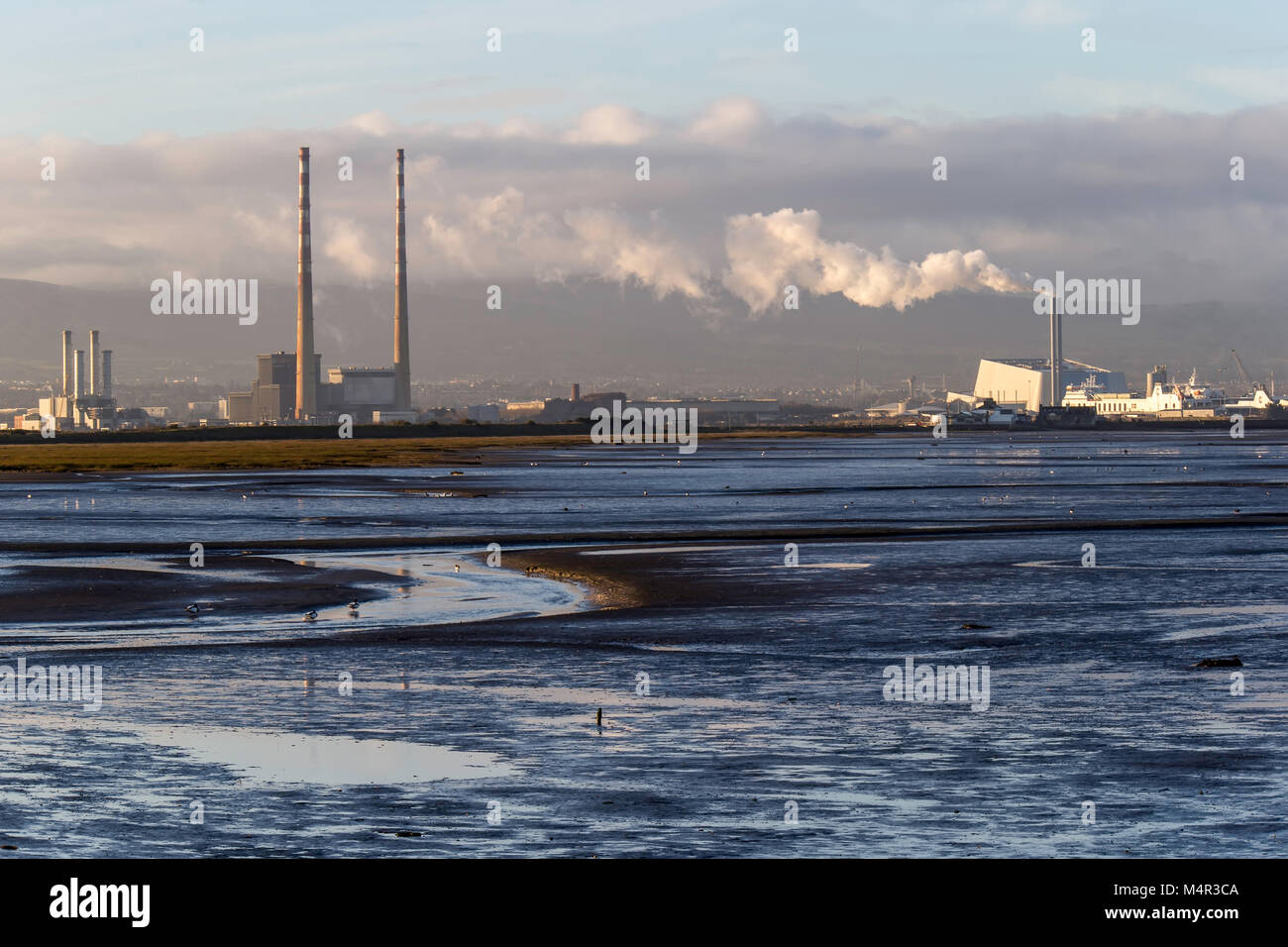 Industrial skyline of Dublin city across Dublin Bay with the Incinerator and Poolbeg chimney's in the View Stock Photo