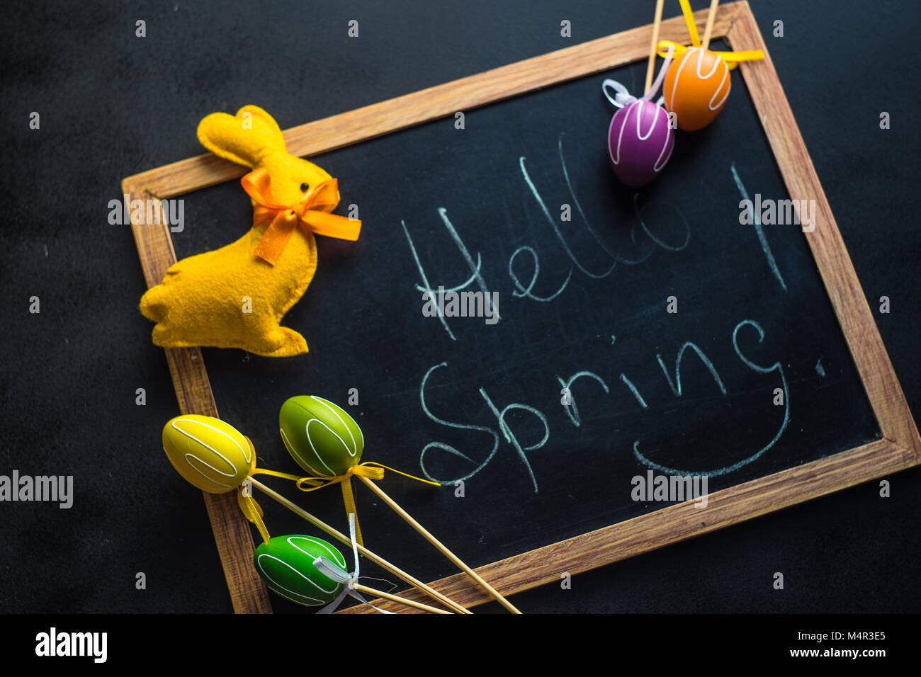 Easter holiday concept with colored easter eggs, easter bunny on chalkboard with Hello spring words and copyspace Stock Photo