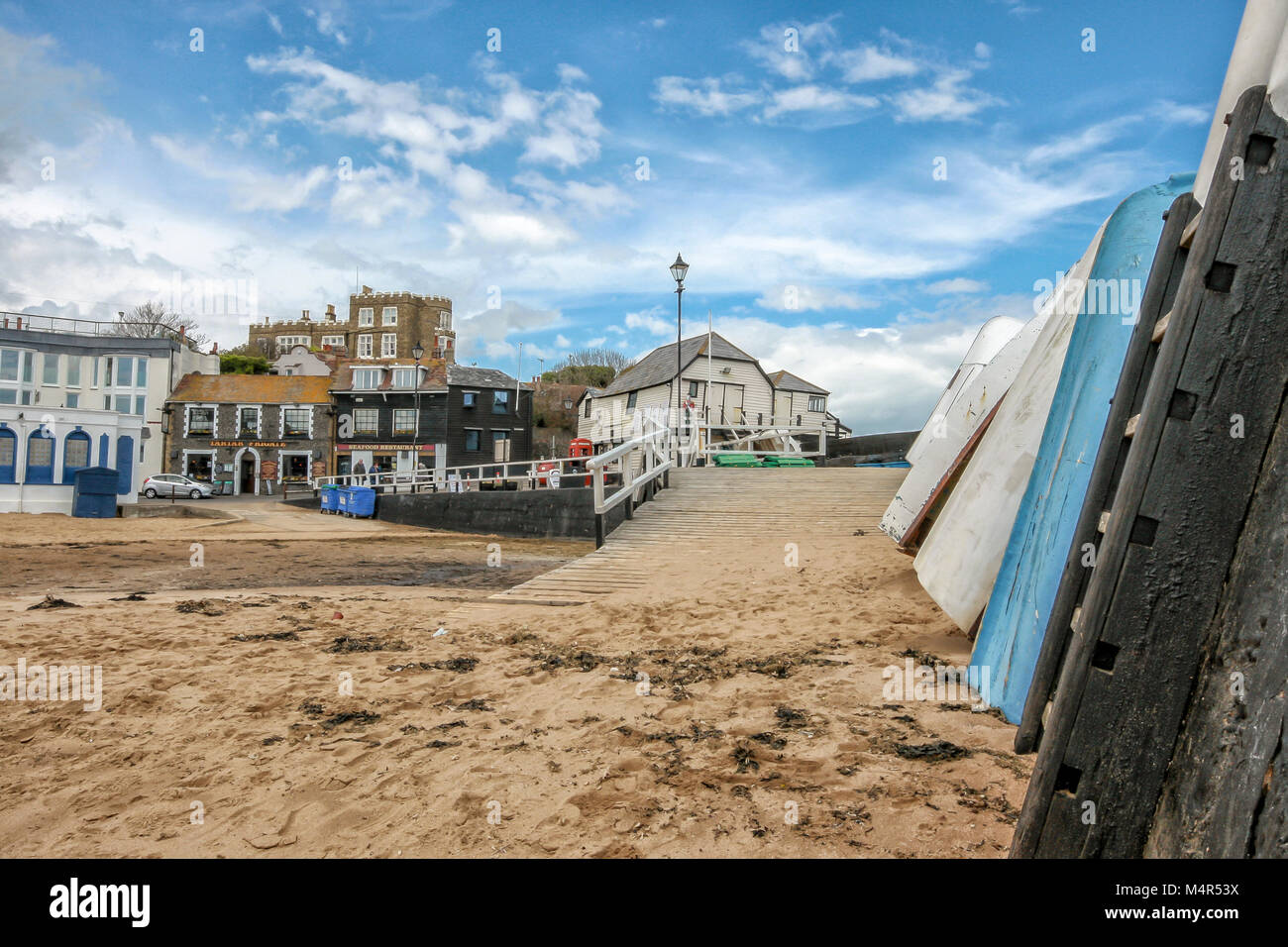 Boats leaning up against harbour wall in Viking Bay, Broadstairs, Kent, England Stock Photo