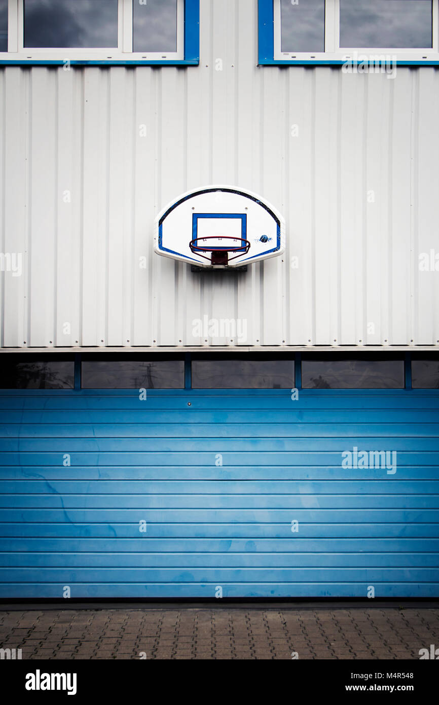 Above the garage door basketball hoop fixed on a white and blue wall. Stock Photo