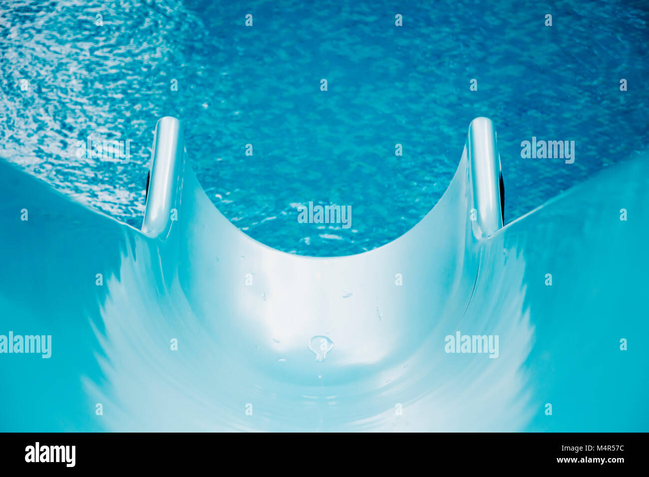 Beautiful blue swimming pool and water slide with water drops for