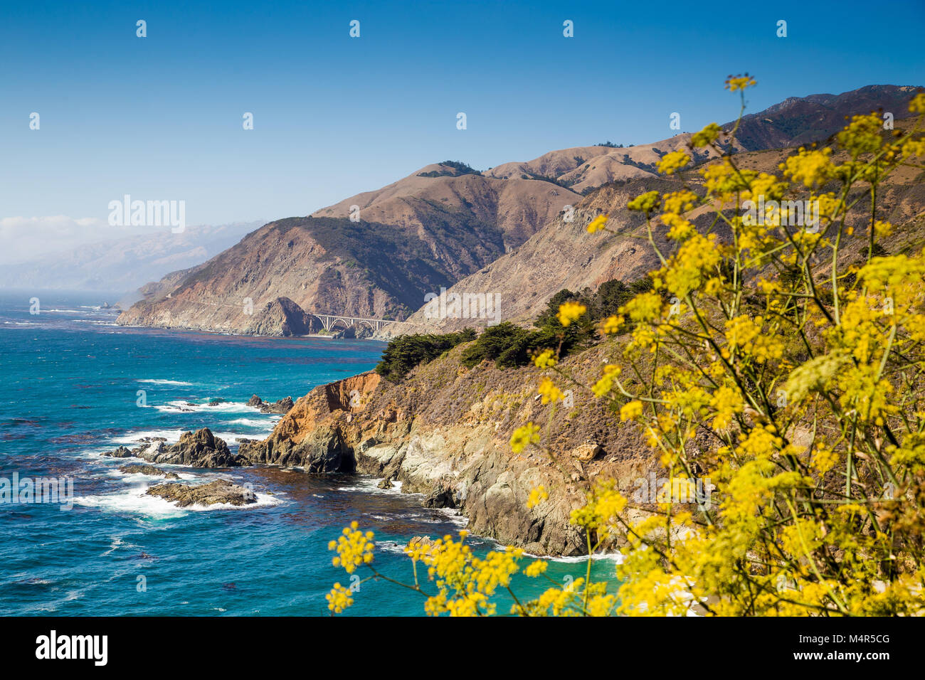 Scenic view of the rugged coastline of Big Sur with Santa Lucia Mountains and Big Creek Bridge along famous Highway 1 at sunset, California, USA Stock Photo