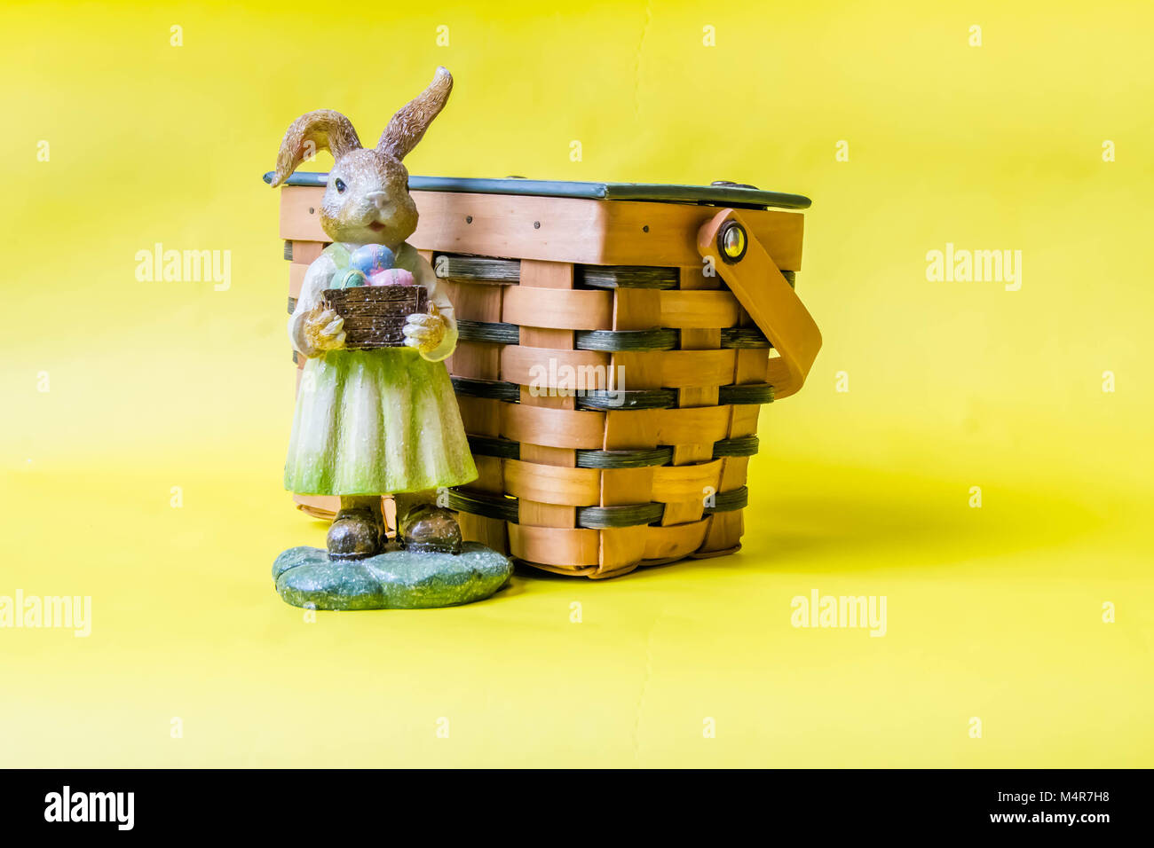 Easter bunny with eggs and basket on a yellow background Stock Photo ...