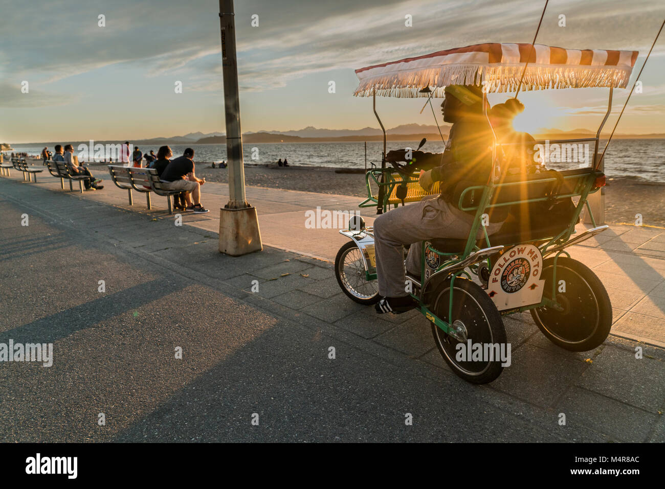 United States, Washington, Relaxing at Alki Beach riding in a pedibike Stock Photo