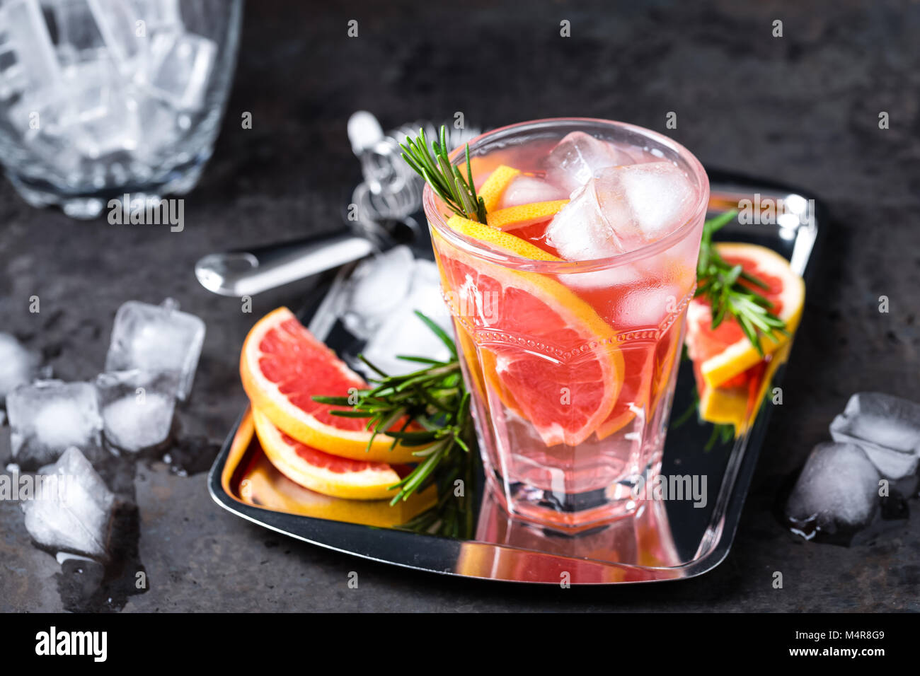 Grapefruit and fresh rosemary gin cocktail with juice, cold summer