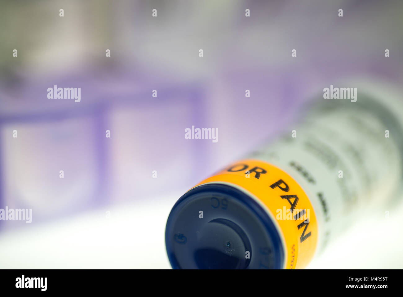 horizontal image of pain medication prescription bottles, weekly pill organizer on white