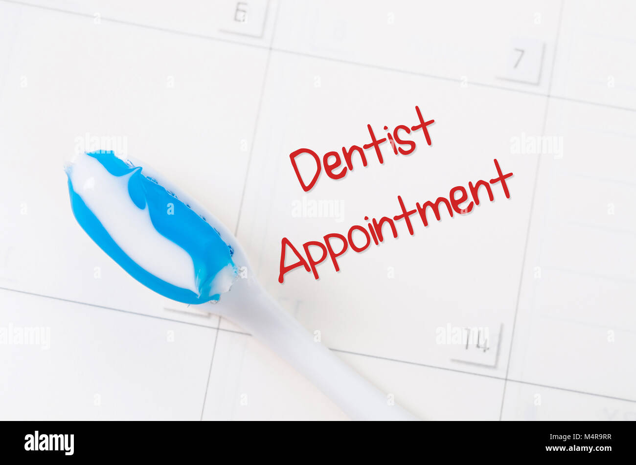 A note of a dentist appointment on a calendar reminds the patient Stock