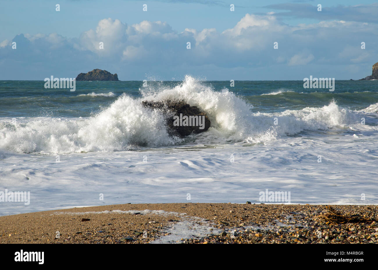 Ocean waves crash against rocks on the approach to the sandy beach ...