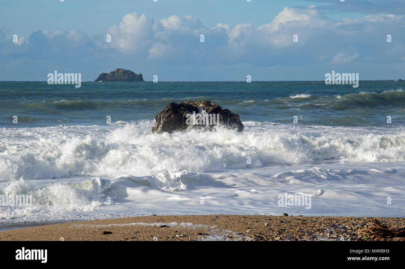 Ocean waves crash against rocks on the approach to the sandy beach ...