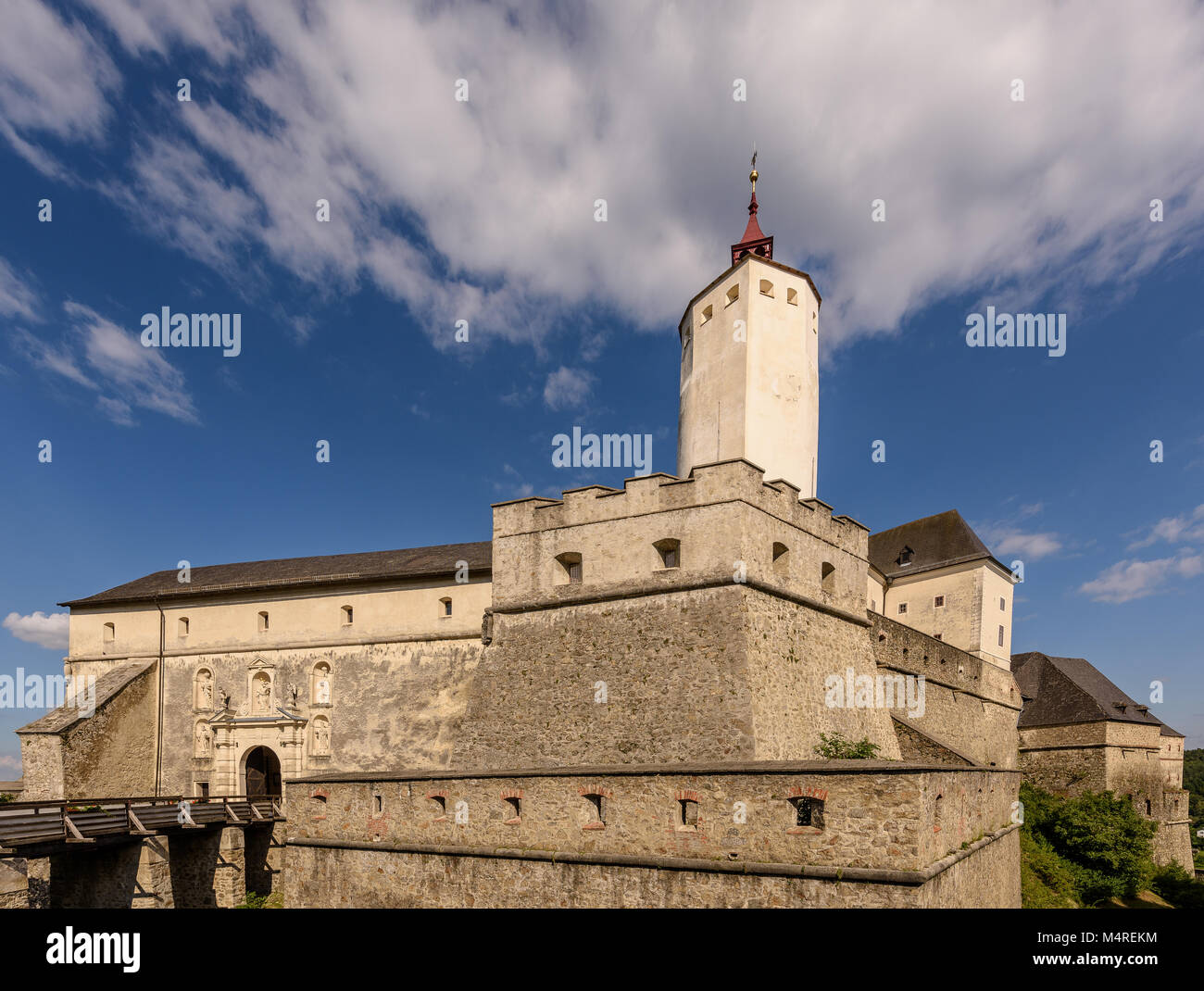 Color outdoor architecture photo of the mdeieval fortress Forchtenstein, Burgenland, Austria. with moat,tower,bridge,sunny day,blue sky, some clouds Stock Photo