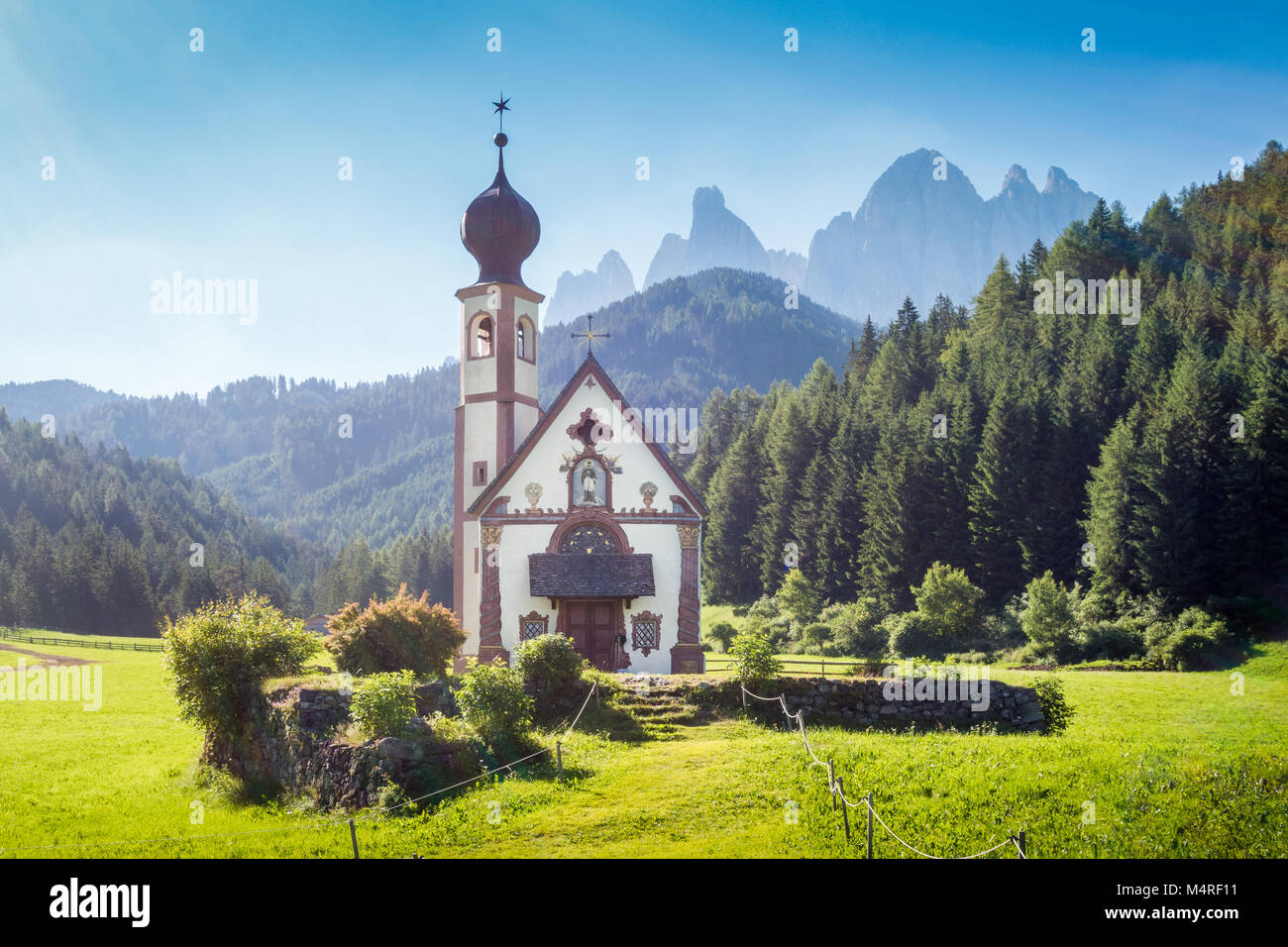Beautiful view of idyllic mountain scenery in the Dolomites with baroque Church of St. Johann of Nepomuk and famous Odle Group in the background Stock Photo