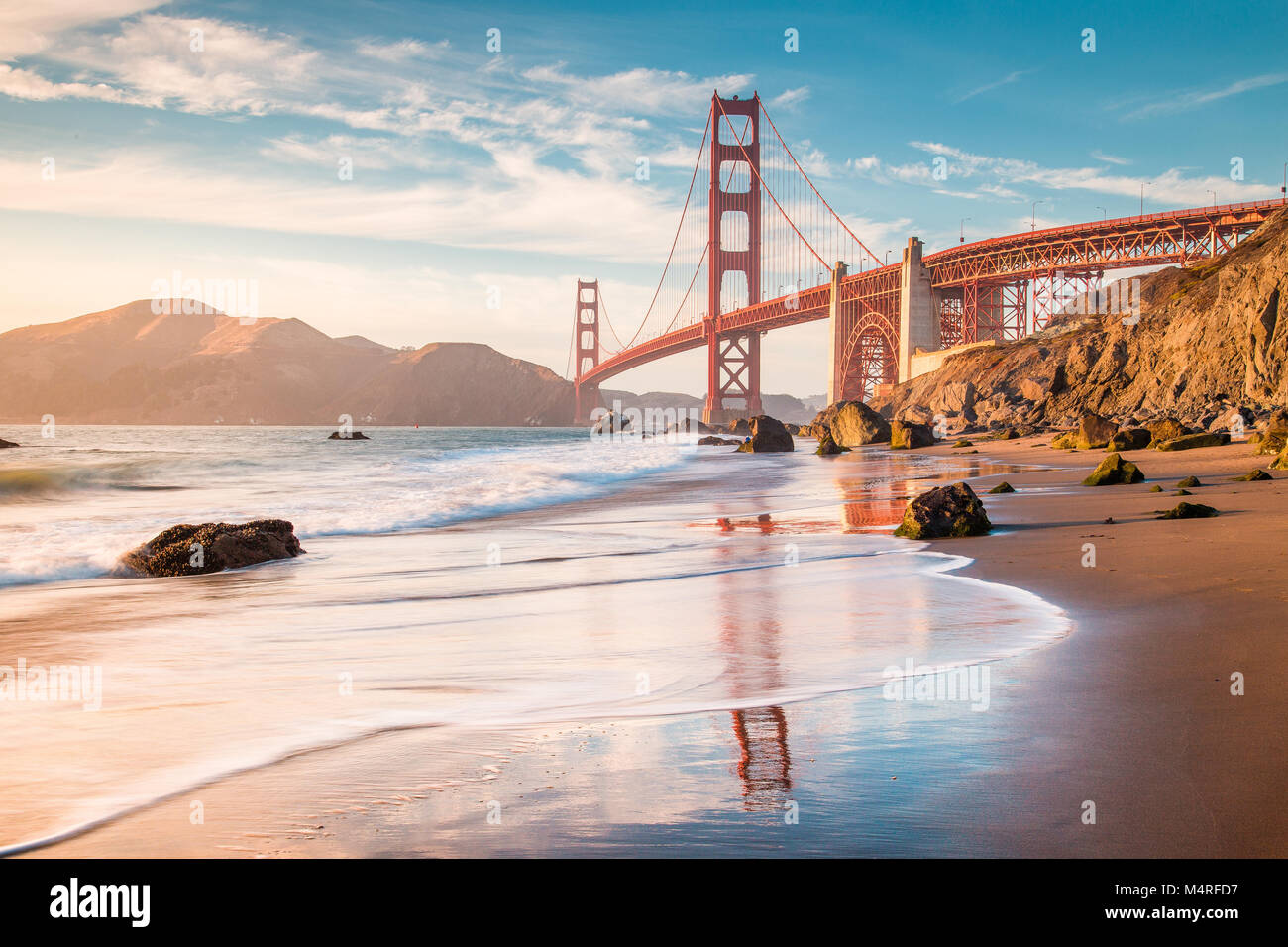 Classic panoramic view of famous Golden Gate Bridge seen from scenic Baker Beach in beautiful golden evening light at sunset, San Francisco, USA Stock Photo