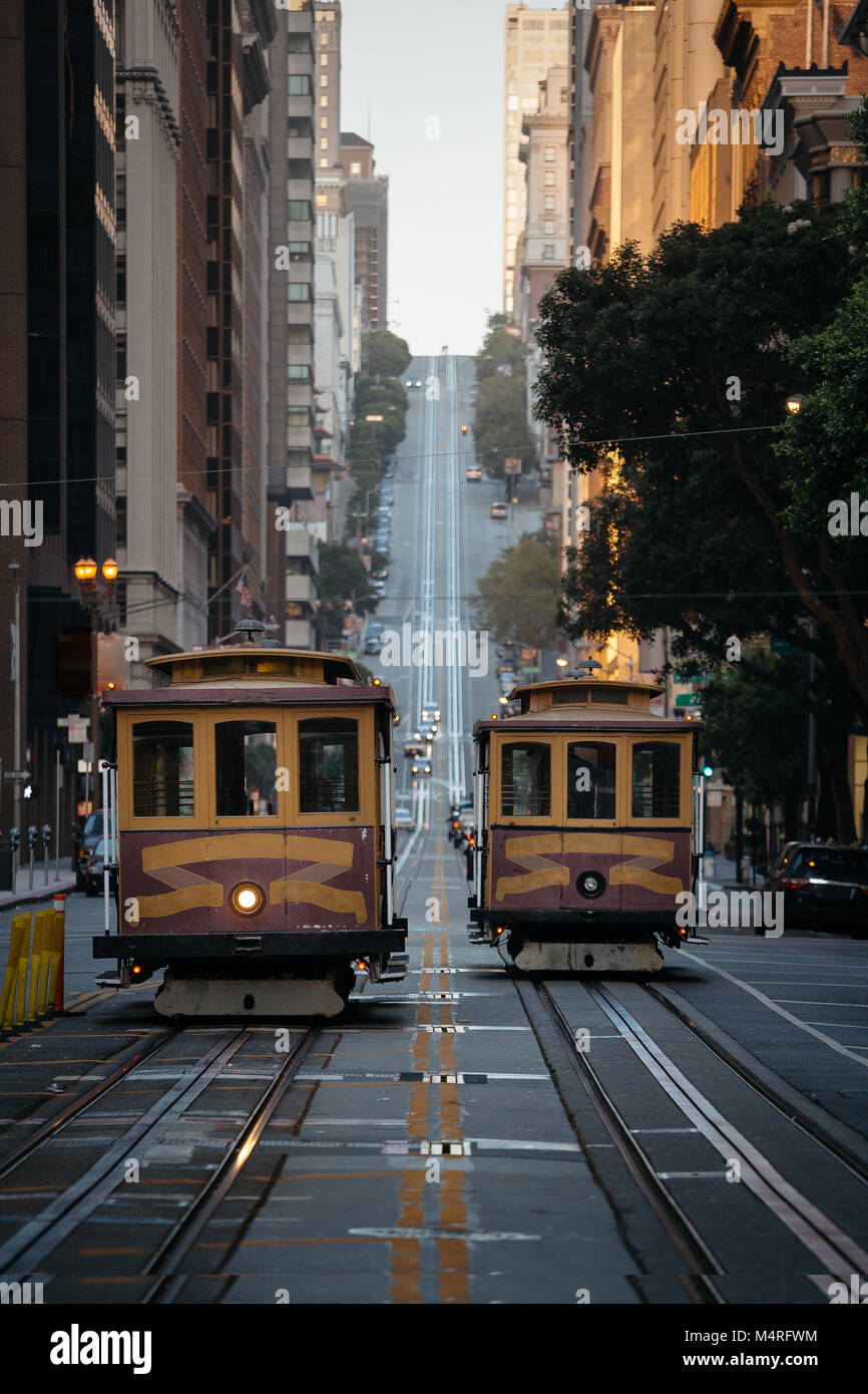 Classic view of historic traditional Cable Cars riding on famous California Street in morning light at sunrise, San Francisco, California, USA Stock Photo