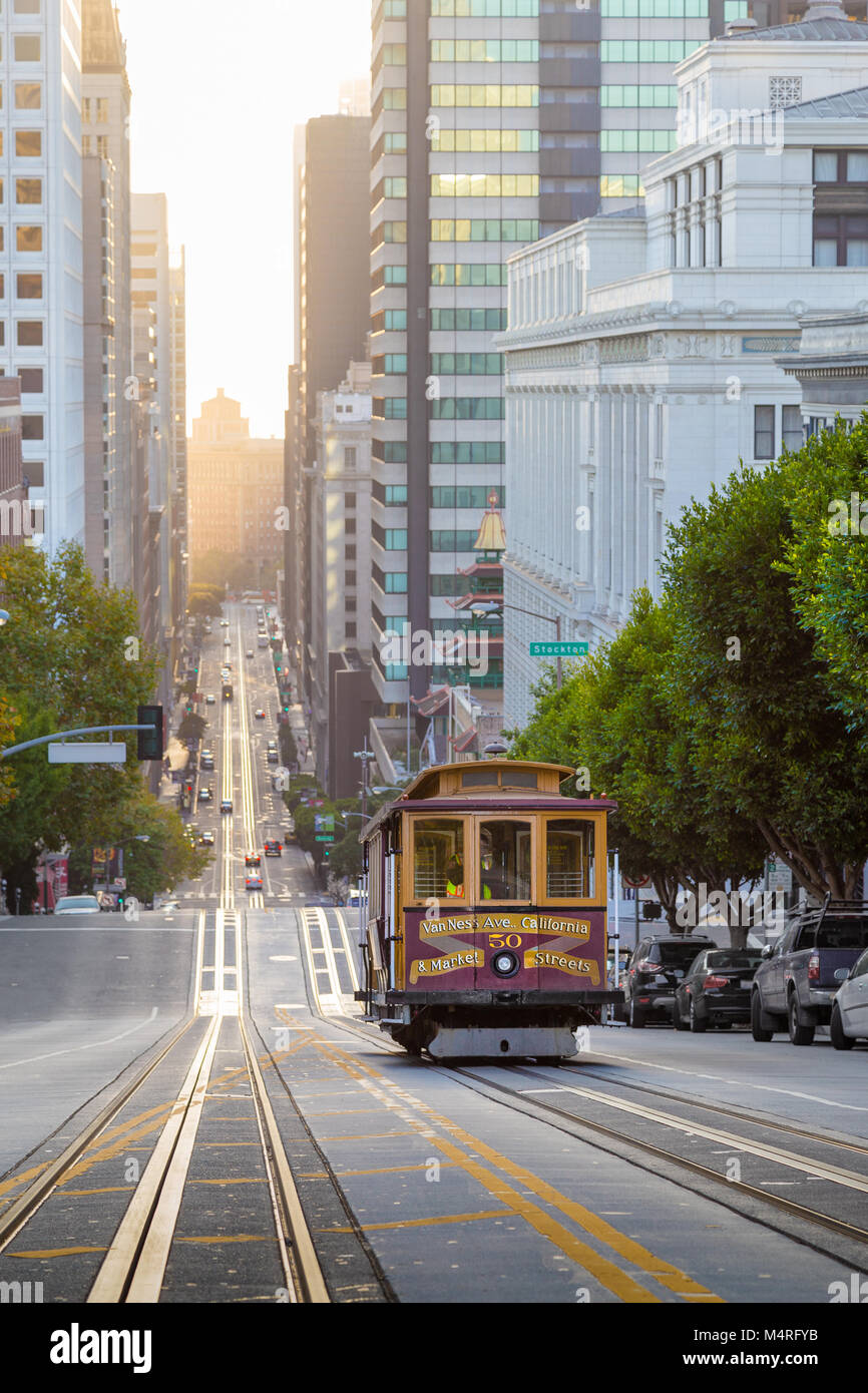 Classic view of historic Cable Car riding on famous California Street in beautiful golden morning light at sunrise in summer, San Francisco, USA Stock Photo