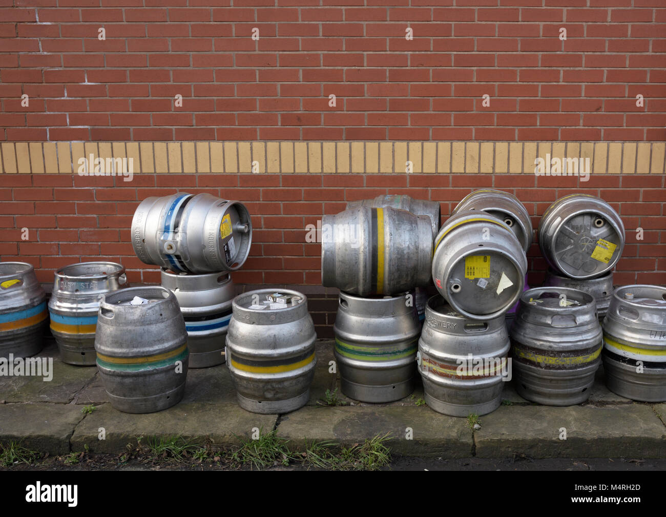 Stainless steel beer casks piled up on stone flag pavement in bury