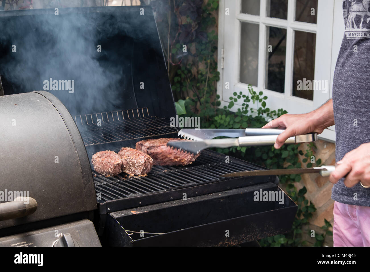 man preparing a brazilian barbecue bbq on charcoal with three pieces of