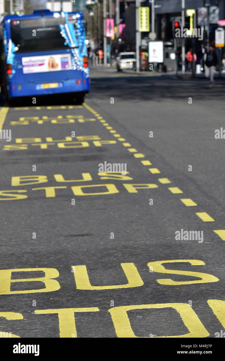 a city centre bus lane in southampton with a blue star bus parked at a bus stop picking up fares