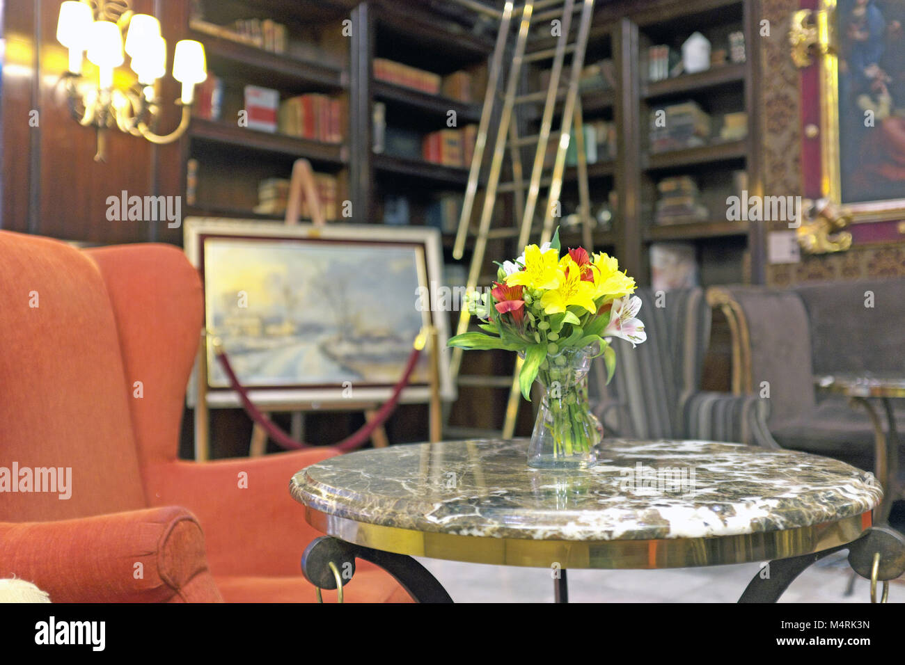 An Orange Chaucer Wing Chair Next To A Cocktail Table With Fresh