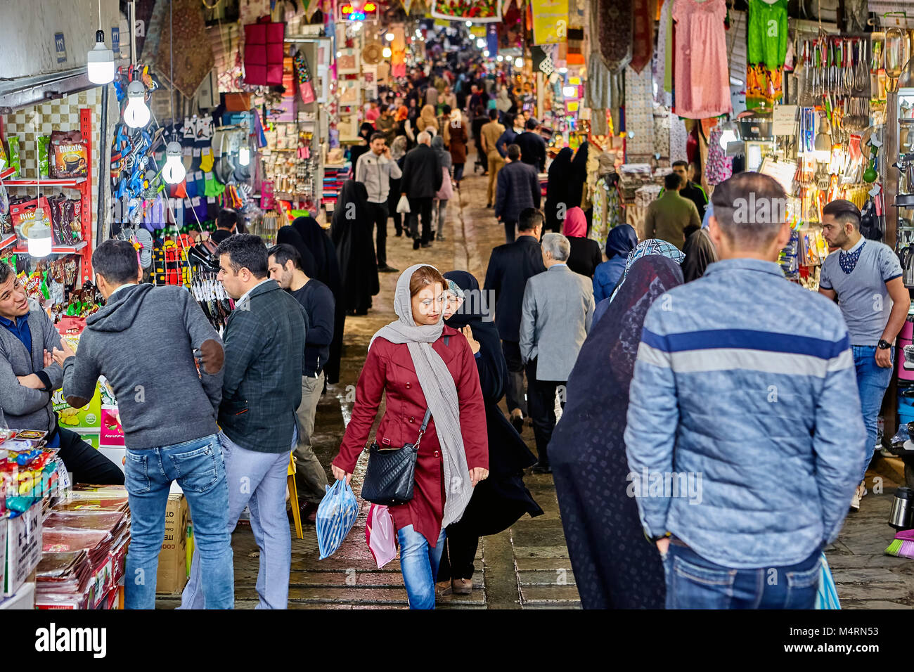 Tehran, Iran - April 29, 2017: Iranian men and women in hijabs stand near the entrance to the big bazaar. Stock Photo