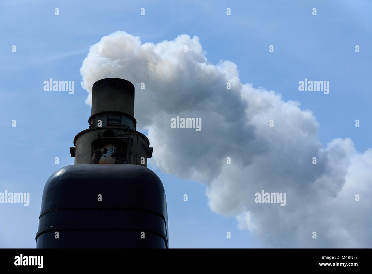 Exhaust pipe of old ship steaming with smoke Stock Photo