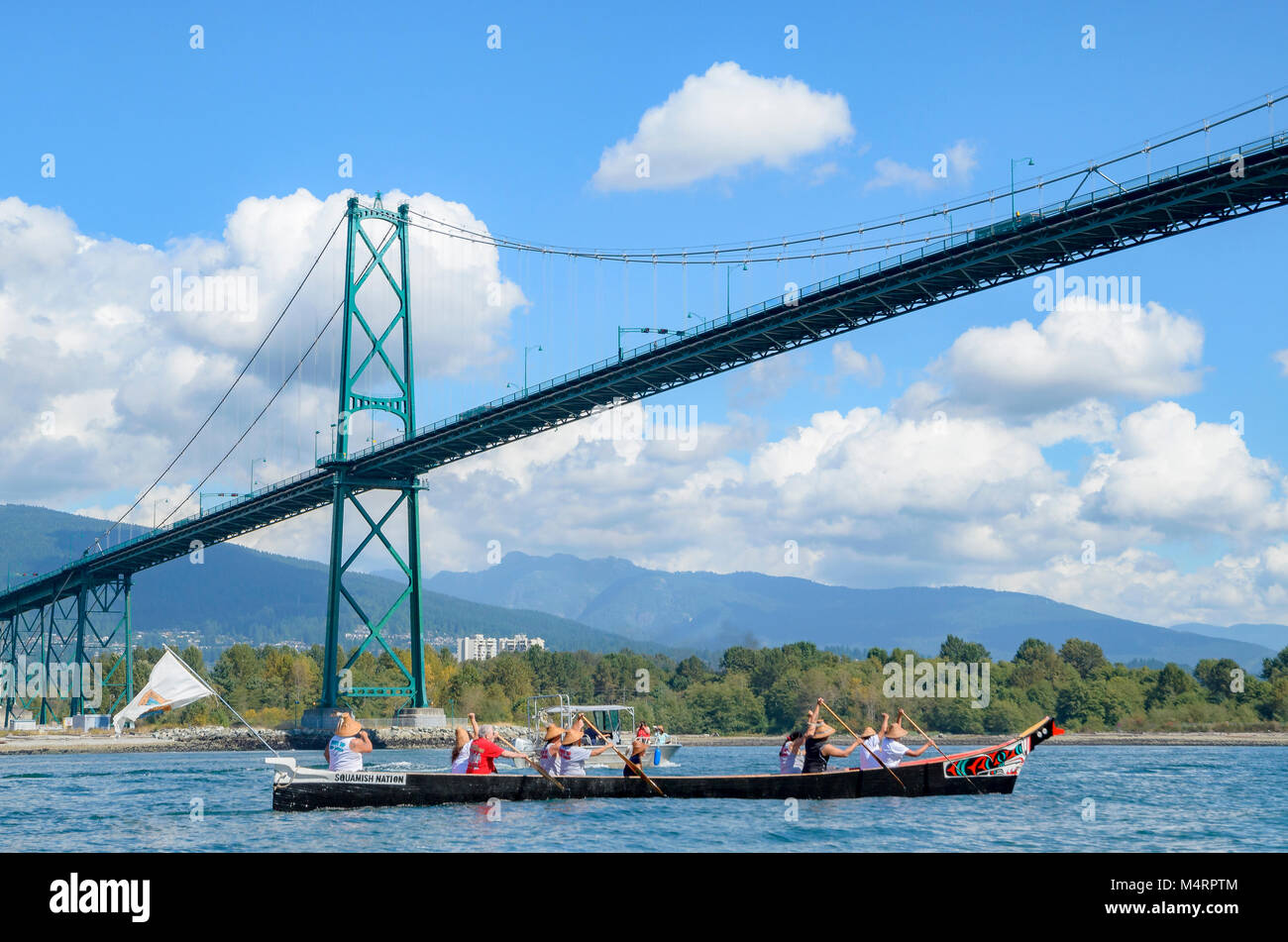 First Nations canoe passes under Lions Gate Bridge. Many People, One Canoe. Salish First Nations, Gathering of Canoes to Protect the Salish Sea, Septe Stock Photo