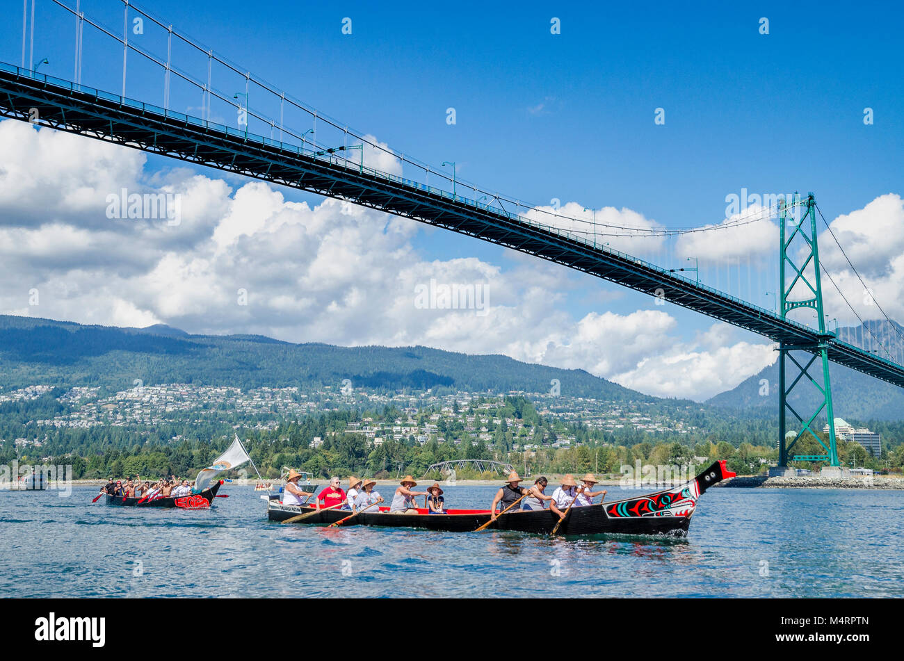 First Nations canoe passes under Lions Gate Bridge. Many People, One Canoe. Salish First Nations, Gathering of Canoes to Protect the Salish Sea, Septe Stock Photo
