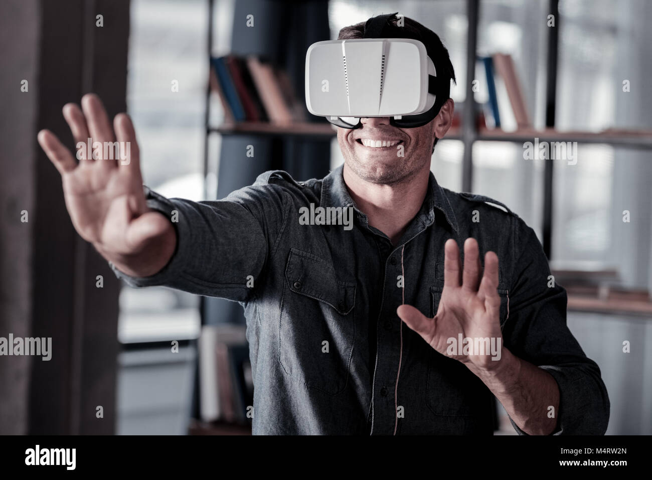 Smiling adult man wearing virtual reality goggles Stock Photo - Alamy