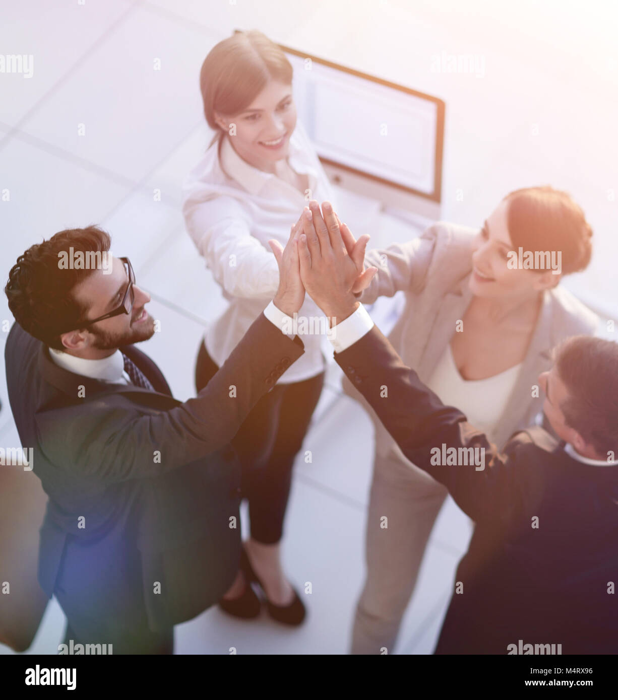 successful business team giving each other a high-five, standing Stock ...