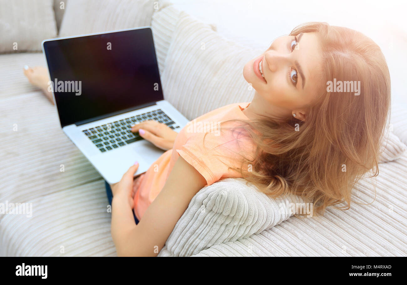portret young woman working with laptop sitting on sofa Stock Photo - Alamy