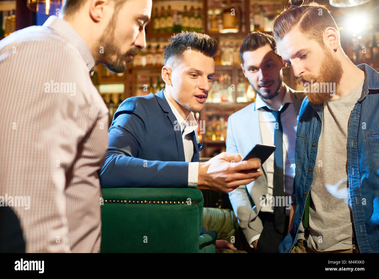 Group of bearded friends gathered together in pub after hard working ...