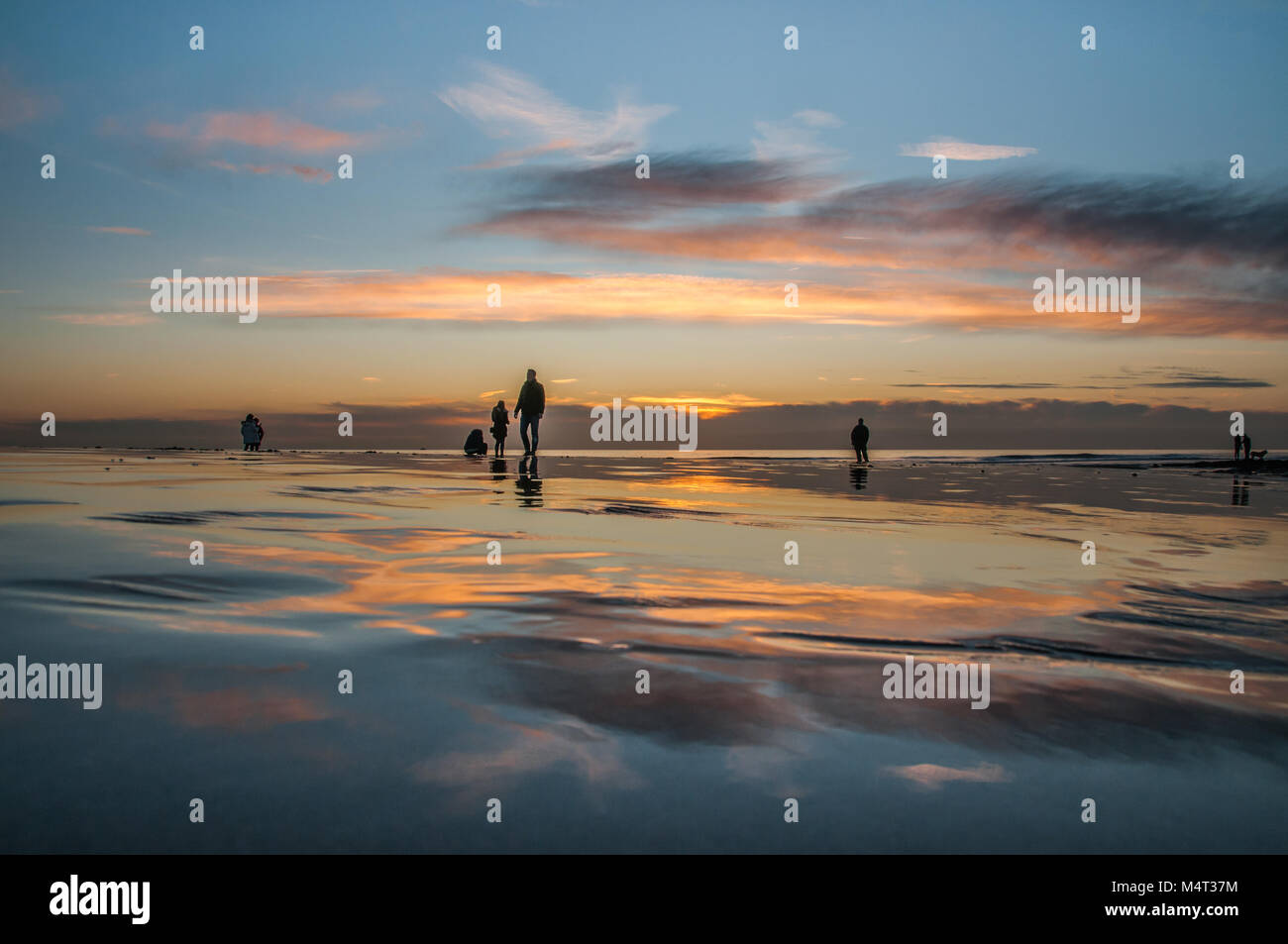 Birling Gap, East Sussex, UK . 17 February 2018..Sunset behind clouds creates spectacular colors  over the wet sand after another glorious Spring like day on the South Coast of England.. David Burr/Alamy Live News Stock Photo