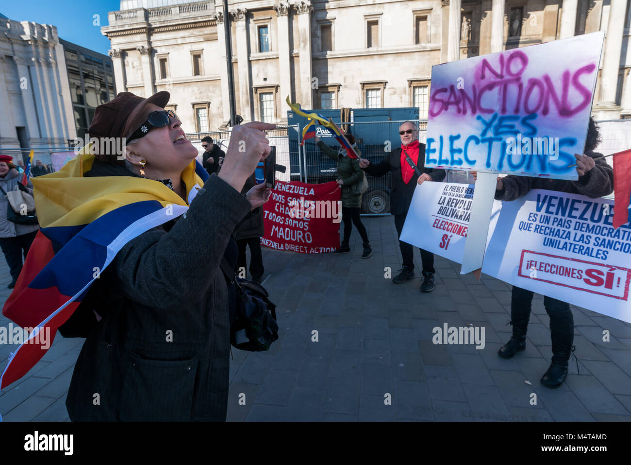 February 17, 2018 - London, UK. 17th February 2018. An emergency rally in Trafalgar Square calls of an end to EU and US economic and diplomatic sanctions against Venezuela in support of the interests of international corporations which make it difficult for the country to recover after the collapse of oil prices in 2015. The latest attack on the country is the US rejection of the 22nd April 2018 election, an attack on Venezuelan sovereignty and the country's right to determine its own destiny. Two women carrying upside-down Venezuelan flags came to interrupt the protest and shout at the prote Stock Photo