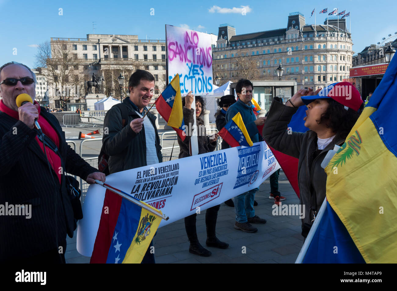 February 17, 2018 - London, UK. 17th February 2018. An emergency rally in Trafalgar Square calls of an end to EU and US economic and diplomatic sanctions against Venezuela in support of the interests of international corporations which make it difficult for the country to recover after the collapse of oil prices in 2015. The latest attack on the country is the US rejection of the 22nd April 2018 election, an attack on Venezuelan sovereignty and the country's right to determine its own destiny. Protesters laugh at two women carrying upside-down Venezuelan flags came to interrupt the protest an Stock Photo