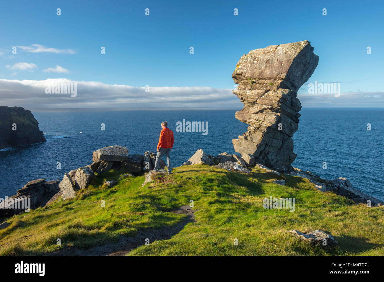 Hiker and rock formation at Hag's Head, Cliffs of Moher coastal walk, County Clare, Ireland. Stock Photo