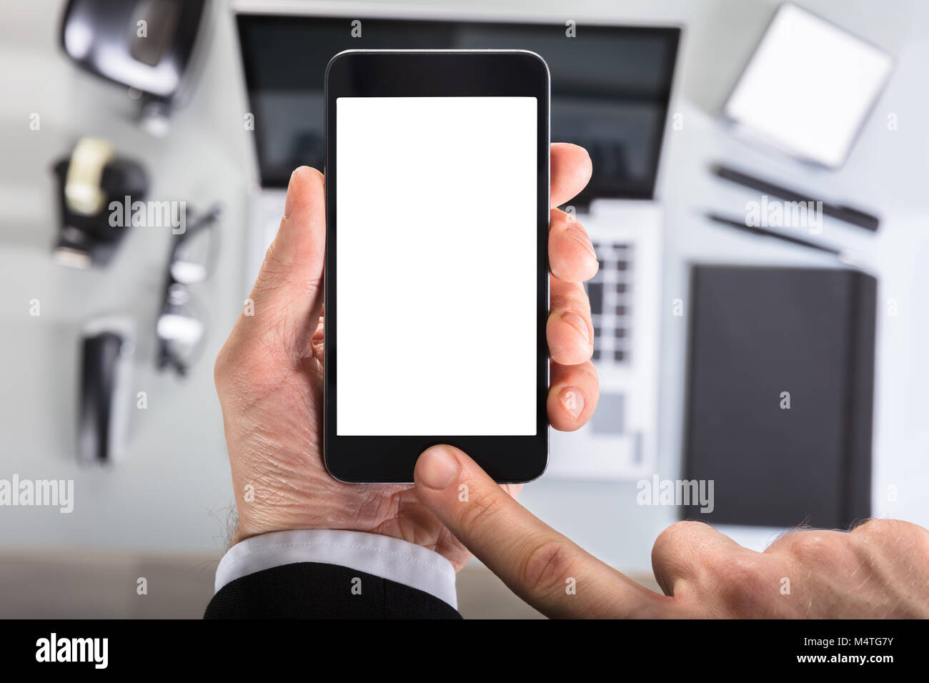 Close-up Of A Businessperson's Hand Showing Smart Phone Blank Screen In Office Stock Photo