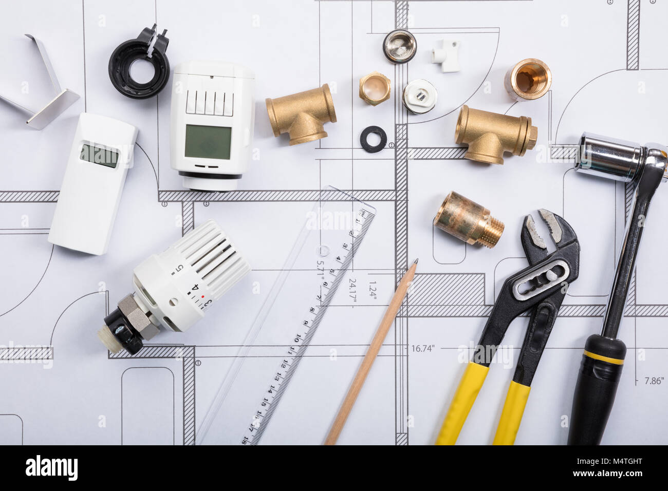 Elevated View Of A Thermostat And Work Tools On Blueprints Stock Photo